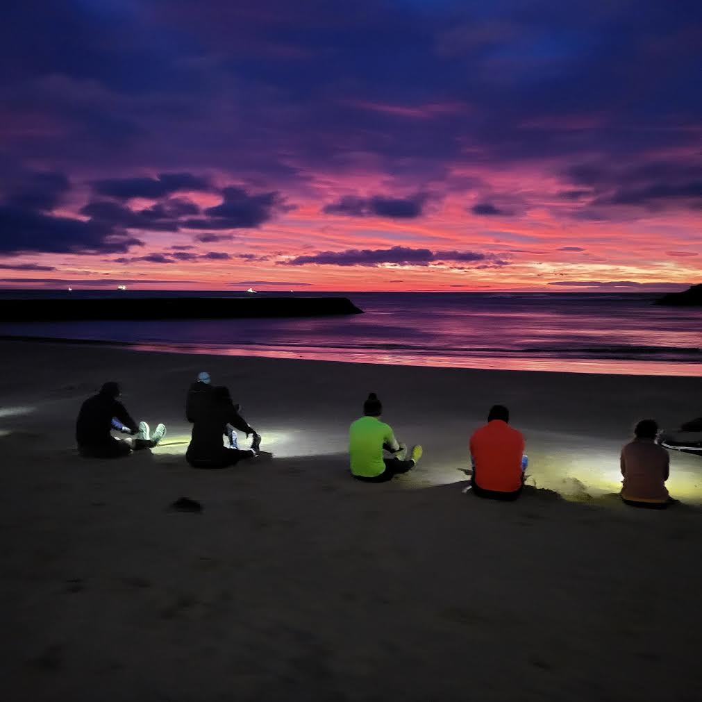 The group watching a pink sunrise on the bay